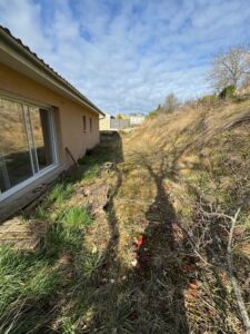 Photo du terrain d'une maison avec vu sur la baie vitrée de la maison