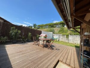 Photo d'une terrasse en bois avec une table et des chaise au centre